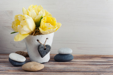 Fototapeta na wymiar Yellow tulip flower, pebbles
