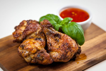 Chicken wings with sweet chilli sauce on the wooden cutting board
