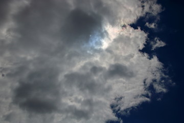 Ciężkie bure chmury zasnuwają niebo, po prawe skraj ciemnoniebieskiego nieba, przez chmury przebija odrobina słonecznego światła i błękitu nieba