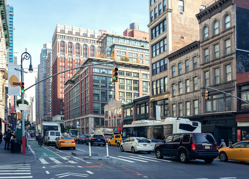 Fototapeta Życie w mieście i ruch na Avenue Avenue (Ladies & 39 Mile Historic District) w świetle dziennym, Nowy Jork, Stany Zjednoczone. Stonowany obraz.