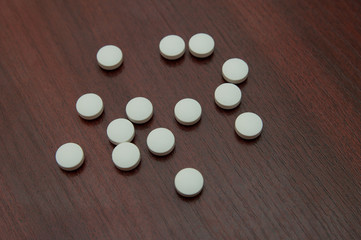 White large pills decomposed on a table .