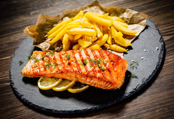 Fried salmonwith french fries on wooden table