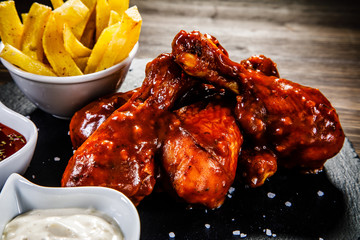 Barbecued drumstick with french fries on wooden table