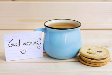 Obraz na płótnie Canvas blue mug of tea and oatmeal cookies on wooden background
