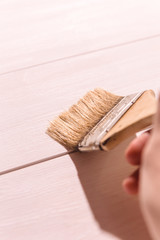 man hand with a paintbrush on wooden background