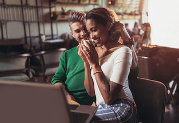 Two happy mixed race couple having fun at the coffee shop
