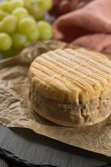 Tasting of oldest french AOC soft pudgent wrapped yellow cheese Livarot from Normandy, french cheese