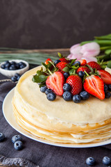 Crepes cake with cottage cheese and strawberry, selective focus on wood table.