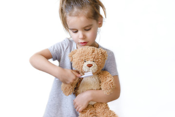 cute girl brushing  teeth her Teddy bear toy.