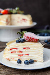 Crepe cake bakery piece with strawberry and vanilla sauce on woo