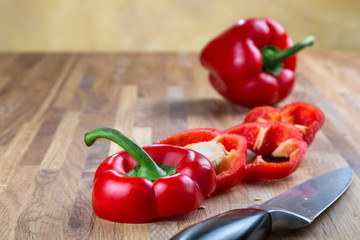 fresh red bell pepper lying on the oak chopping Board