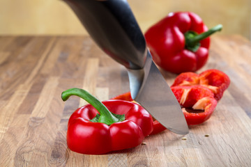 fresh red bell pepper lying on the oak chopping Board