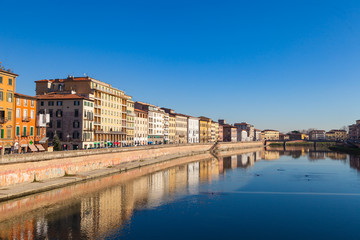 Fototapeta na wymiar Arno river embankment with colorful old houses in Pisa. Picturesque medieval town of Pisa from bridge Ponte di Mezzo, Pisa, Tuscany, Italy.