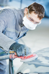 auto repairman grinding autobody bonnet