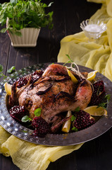 Baked chicken in the oven. Serving with pomegranate and lemon on a large metal dish.