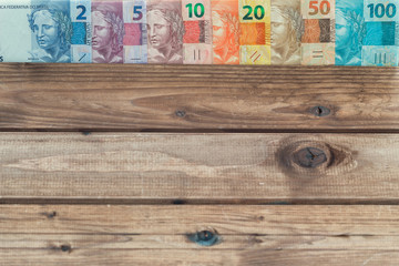 brazilian money all denominations on the wooden background  with place for a text.