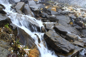 Waterfall flowing among the stones. Water in the mountains