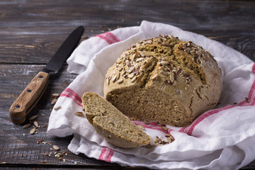 Simple rustic rye oat bread without yeast with seeds on a wooden table, selective focus