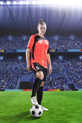 Naklejka premium female football player in red uniform on soccer field