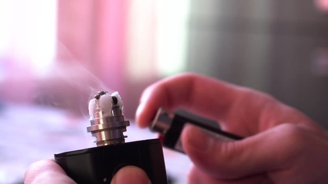 Maintenance of electronic fur modem. Master of repair of the evaporator.man sets fire to cotton wool