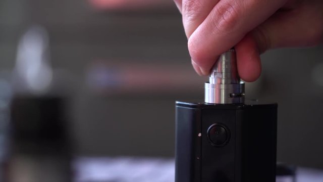 Maintenance of electronic fur modem. Master of repair of the evaporator.man puts the lid on the evaporator