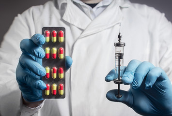 Photo of a lab assistant in outfit holding a pills blister and syringe.