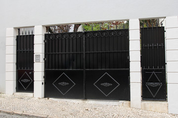 elegant, black entrance gate in white wall