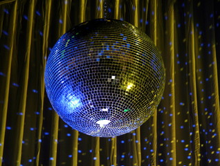 night club lighting blue mirror-ball over curtains