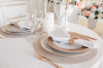 Close-up layout of the festive table. decorated table and chairs for a festive dinner. Luxury decor with daylight. modern photographic studio. Light spring room studio interior.