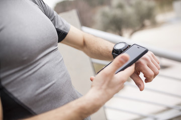 runner synchronizing his watch and smart phone