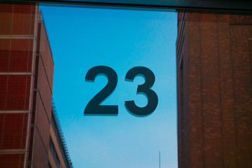 number 23 door sign with glass reflections