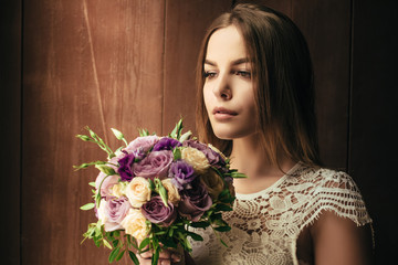 girl holding flowers in hands, young beautiful bride in white dress holding wedding bouquet, bouquet of bride from rose cream spray, rose bush, rose purple Memory Lane, violet eustoma, eucalyptus