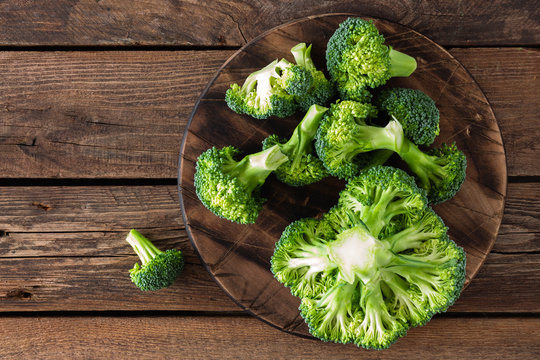 Fresh broccoli on wooden rustic table, top view