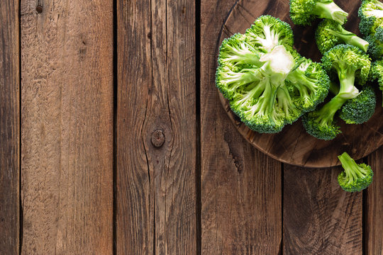 Fresh broccoli on wooden rustic table, top view