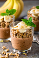 Layered chocolate chia pudding parfait with banana, granola and yogurt, dessert