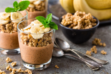 Layered chocolate chia pudding parfait with banana, granola and yogurt, dessert