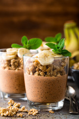 Layered chocolate chia pudding parfait with banana, granola and yogurt, dessert
