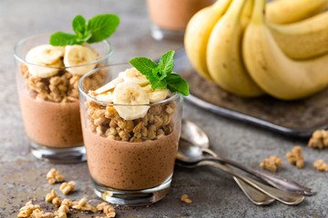 Layered chocolate chia pudding parfait with banana, granola and yogurt, dessert