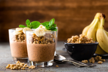 Layered chocolate chia pudding parfait with banana, granola and yogurt, dessert