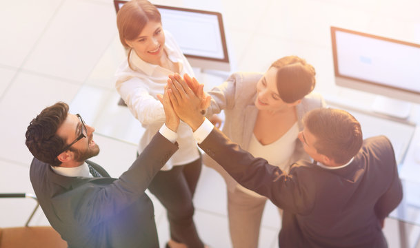 successful business team giving each other a high-five, standing