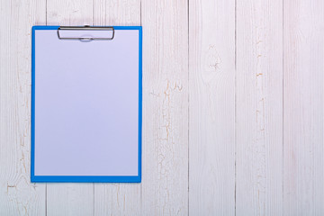 clipboard with blank white paper sheet on wood table top view with copy space.