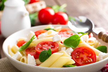 Pasta salad with fresh red cherry tomato and feta cheese. Italian cuisine