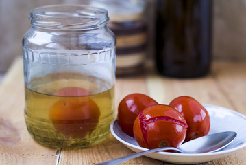Canned tomatoes in a small plate with a spoon and a jar