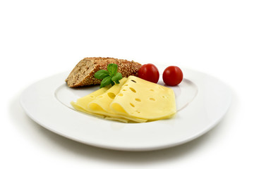 Slice of cheese with garnish stock images. Piece of cheese with tomatoes and basil. Cheese isolated on a white background. Healthy snack images