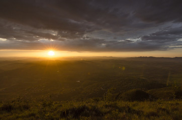A sunset in clouds by the mountain