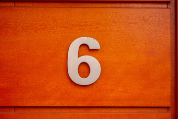 number 6 door sign on red background