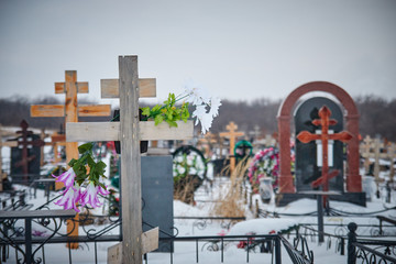 Orthodox cross in the cemetery. artificial flowers