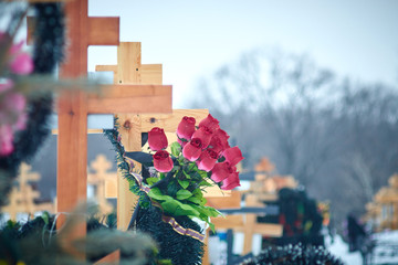 Orthodox cross in the cemetery. artificial flowers