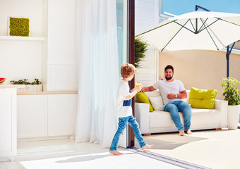 happy family relaxing on rooftop patio with open space kitchen at warm summer day