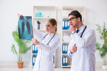 Two doctors examining x-ray images of patient for diagnosis